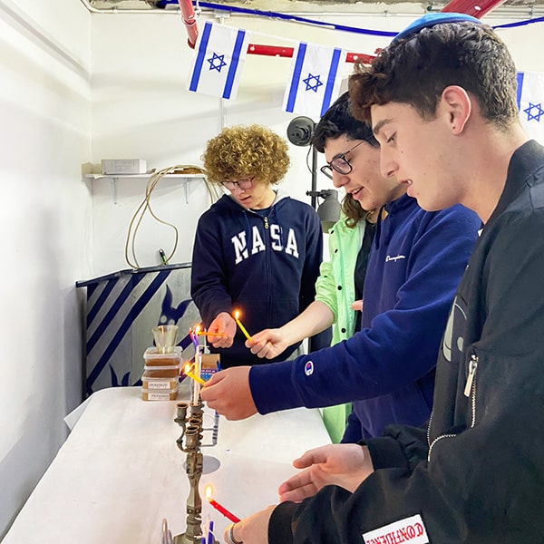 Nethaniel, david and elijah light the candles in jerusalem