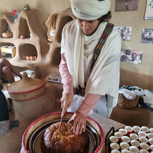 Adam, from colombia, cuts dabo, a special ethiopian bread